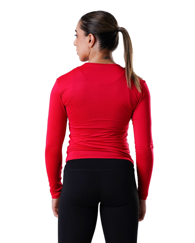 Person wearing a red long-sleeve athletic top and black leggings on a white background