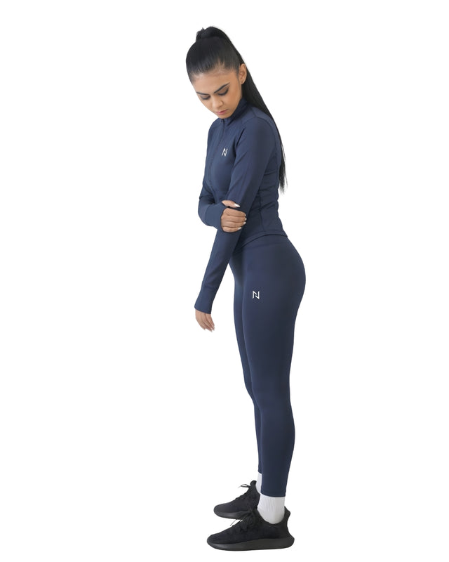 Woman wearing a navy blue athletic outfit with a logo on a white background