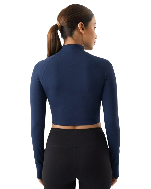Woman wearing a navy long-sleeve athletic top on a white background