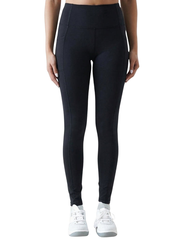 Person wearing black leggings with white sneakers on a white background