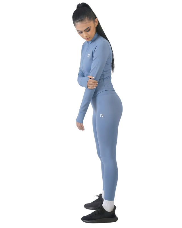 Woman wearing a blue athletic outfit with a logo on a white background