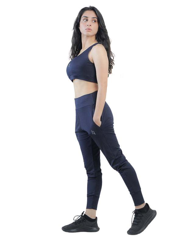Woman wearing a navy blue athletic outfit on a white background