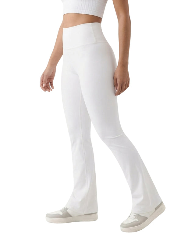 Person wearing white flared pants on a white background
