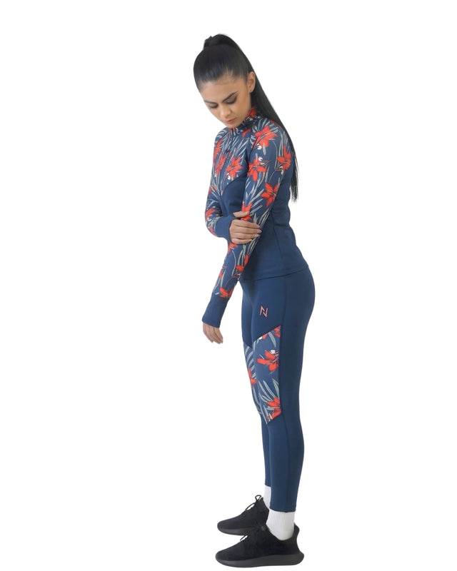 Woman wearing a blue athletic outfit with red floral patterns on a white background
