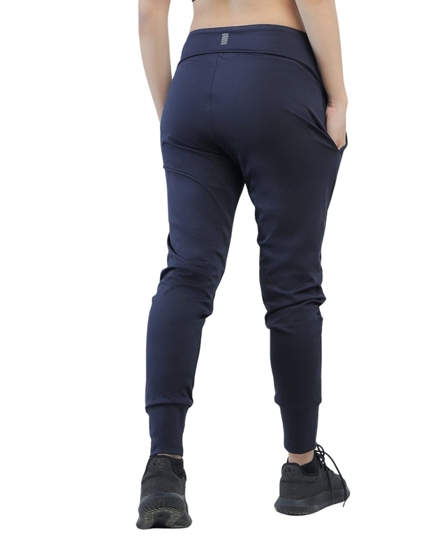 Person wearing navy blue jogger pants on a white background