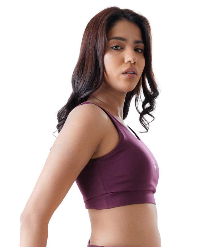 Woman wearing a purple sports bra on a white background
