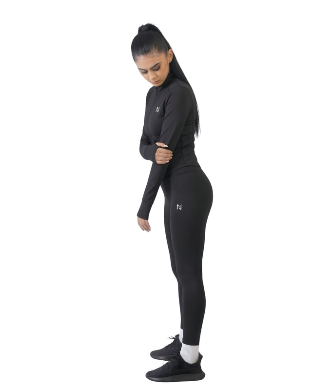 Woman wearing a black athletic outfit with a logo on a white background