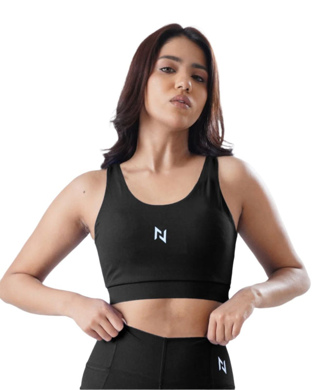 Woman wearing a black sports bra with a logo on a white background