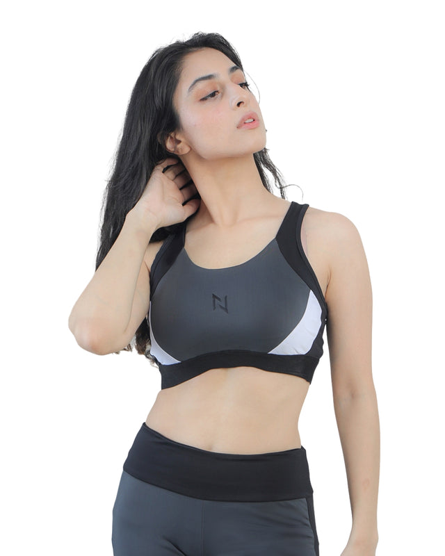 Woman wearing a gray sports bra with a logo on a white background