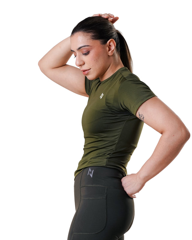 Woman wearing a green athletic shirt and black leggings on a white background