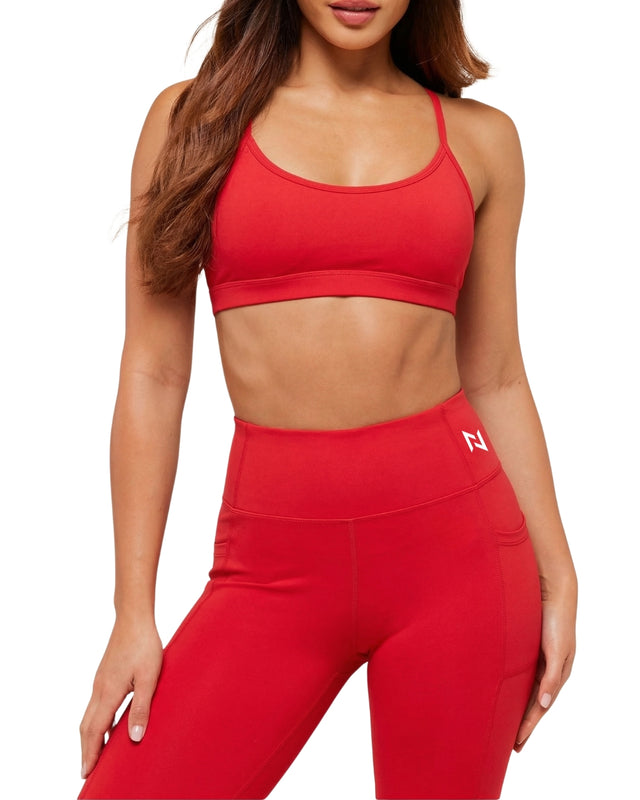 Person wearing a red sports bra and leggings on a white background