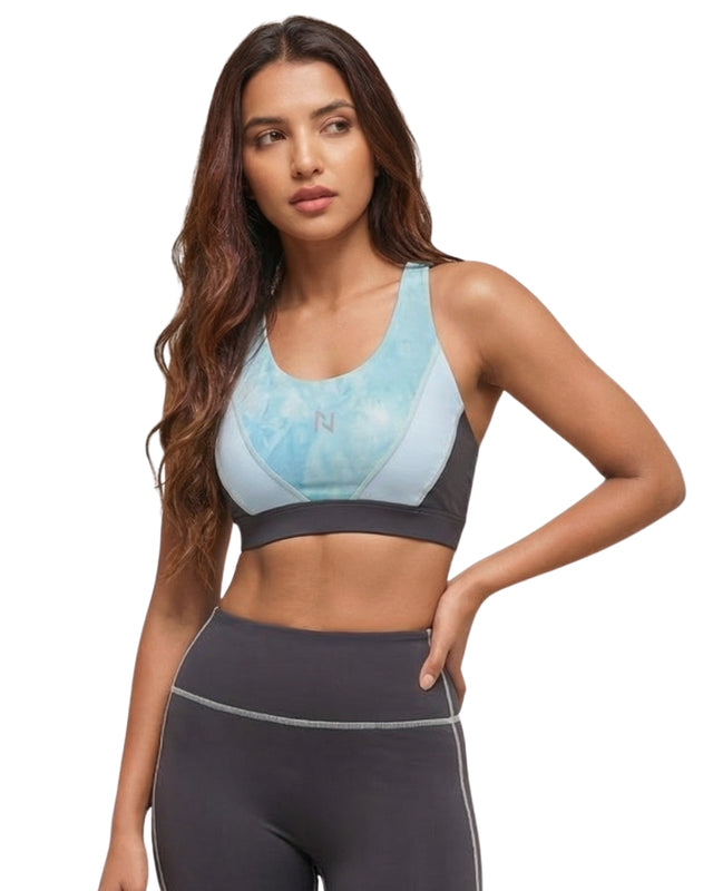 Woman wearing a sports bra and leggings on a white background