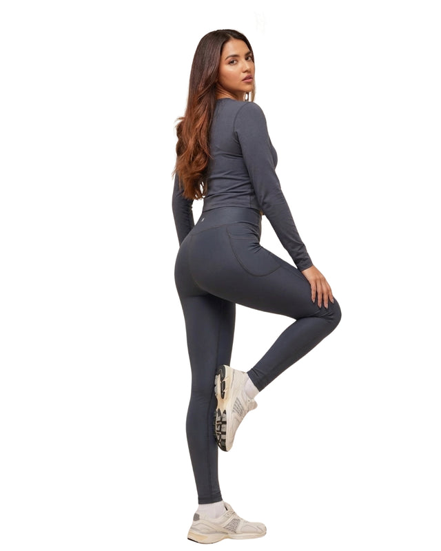 Woman wearing a gray athletic outfit on a white background