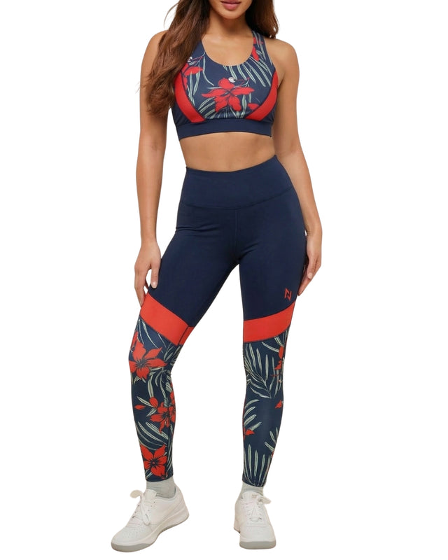 Woman wearing a navy and red sports bra and leggings set on a white background