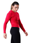 Woman wearing a red long-sleeve top and black pants on a white background