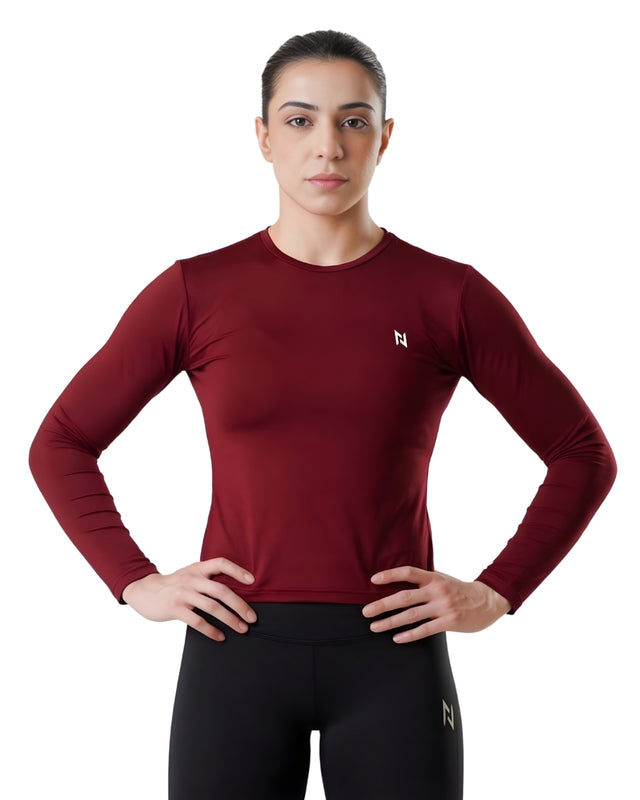 Person wearing a maroon long-sleeve athletic shirt with a logo on a white background