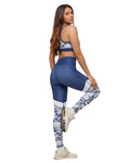 Woman wearing blue and white patterned leggings with a sports bra on a white background
