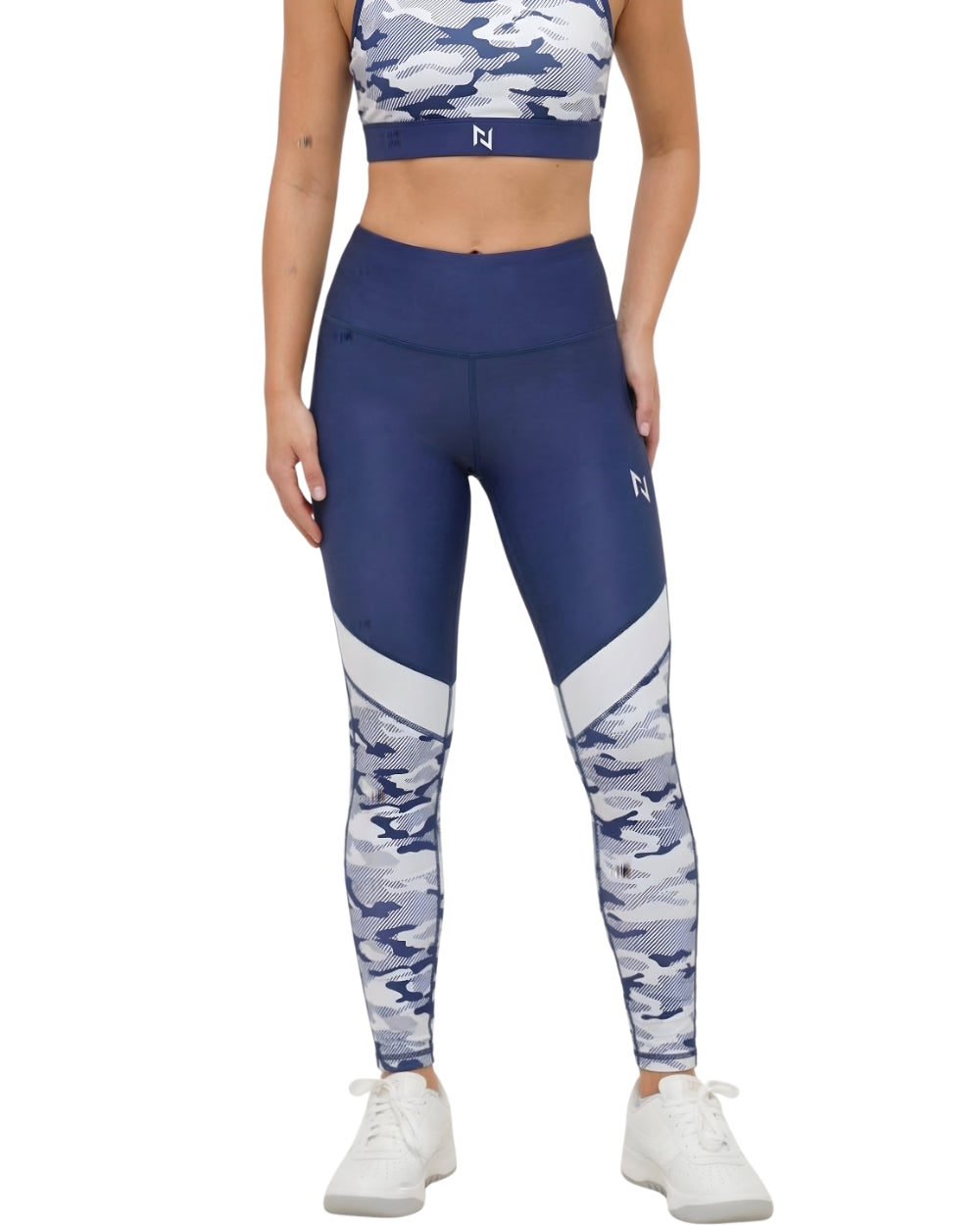 Woman wearing blue and white camouflage leggings with a matching sports bra on a white background