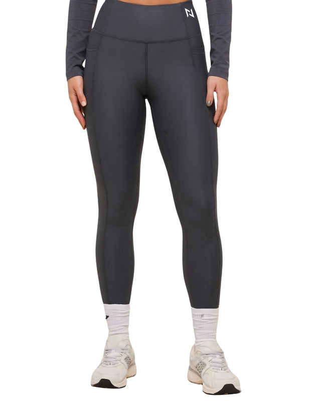 Person wearing dark gray leggings with a white logo on a white background