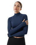 Woman wearing a blue turtleneck sweater against a white background