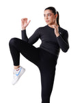 Woman in black athletic wear with a white background