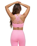 Woman wearing a pink sports bra and leggings set on a white background