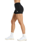 Black athletic shorts with a logo worn by a person on a white background