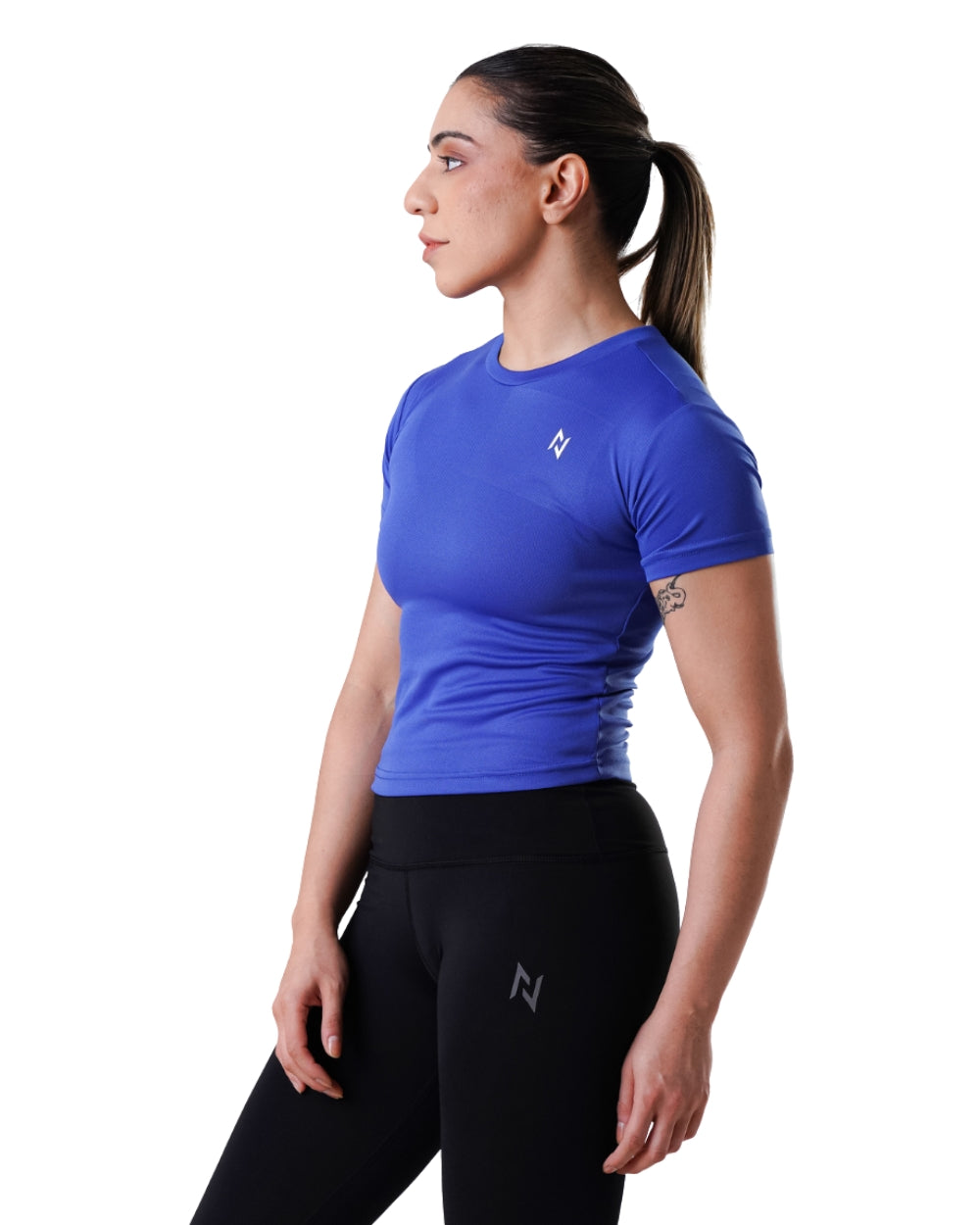 Woman wearing a blue athletic shirt and black leggings with a logo on a white background