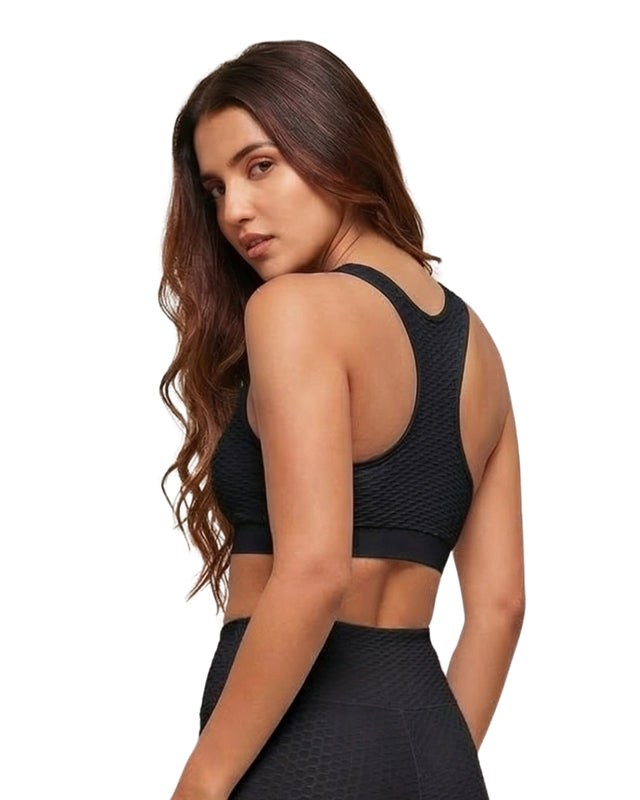 Woman wearing a black sports bra and leggings on a white background
