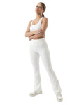 Woman wearing a white tank top and pants on a white background