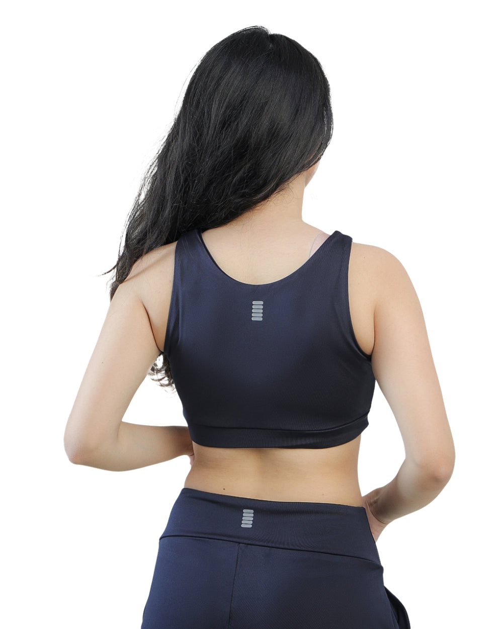 Person wearing a navy sports bra and leggings on a white background