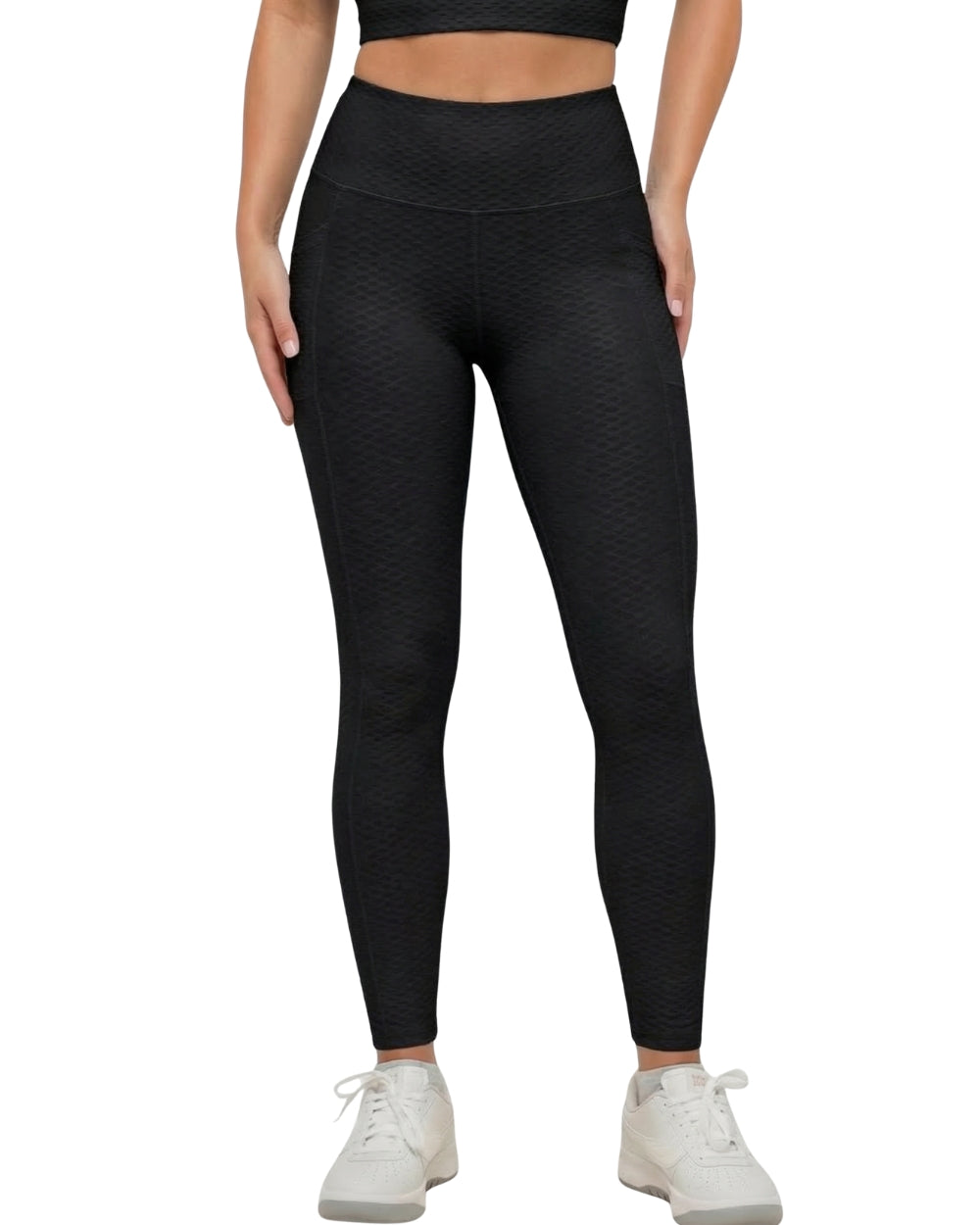 Person wearing black textured leggings on a white background