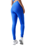 Person wearing blue leggings on a white background