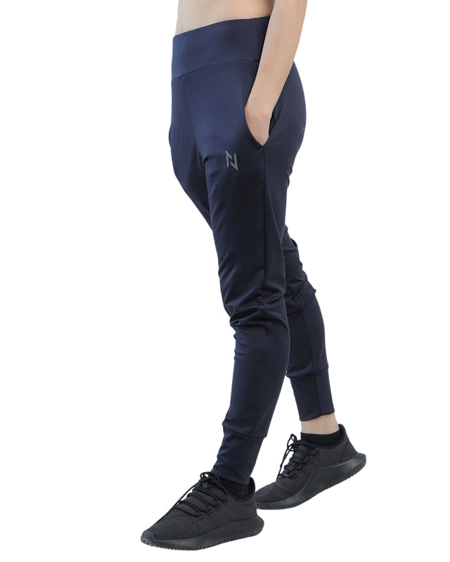 Person wearing navy blue jogger pants with a brand logo on a white background