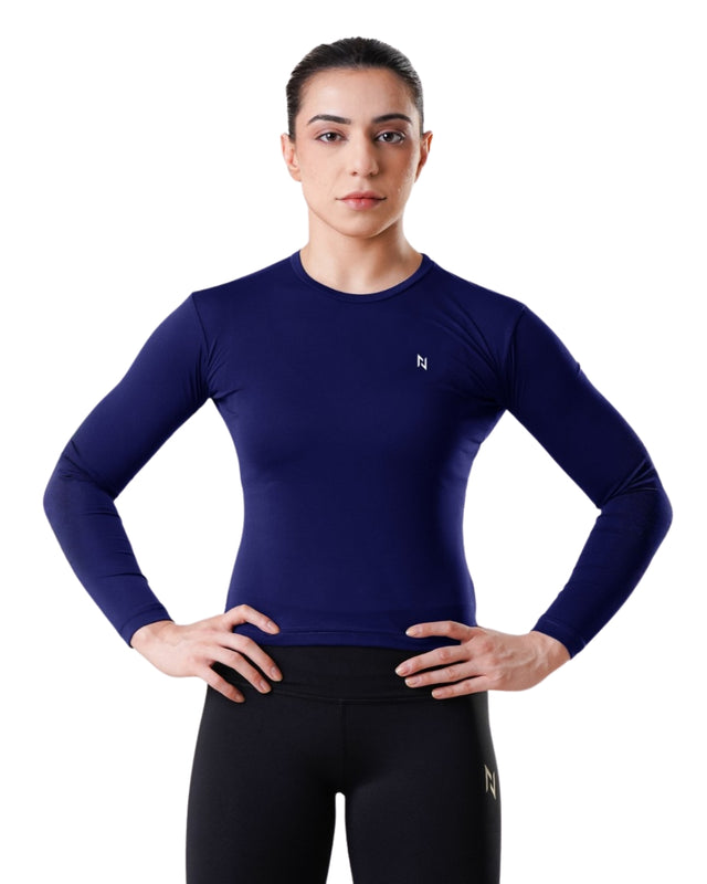 Person wearing a blue long-sleeve athletic shirt and black leggings on a white background
