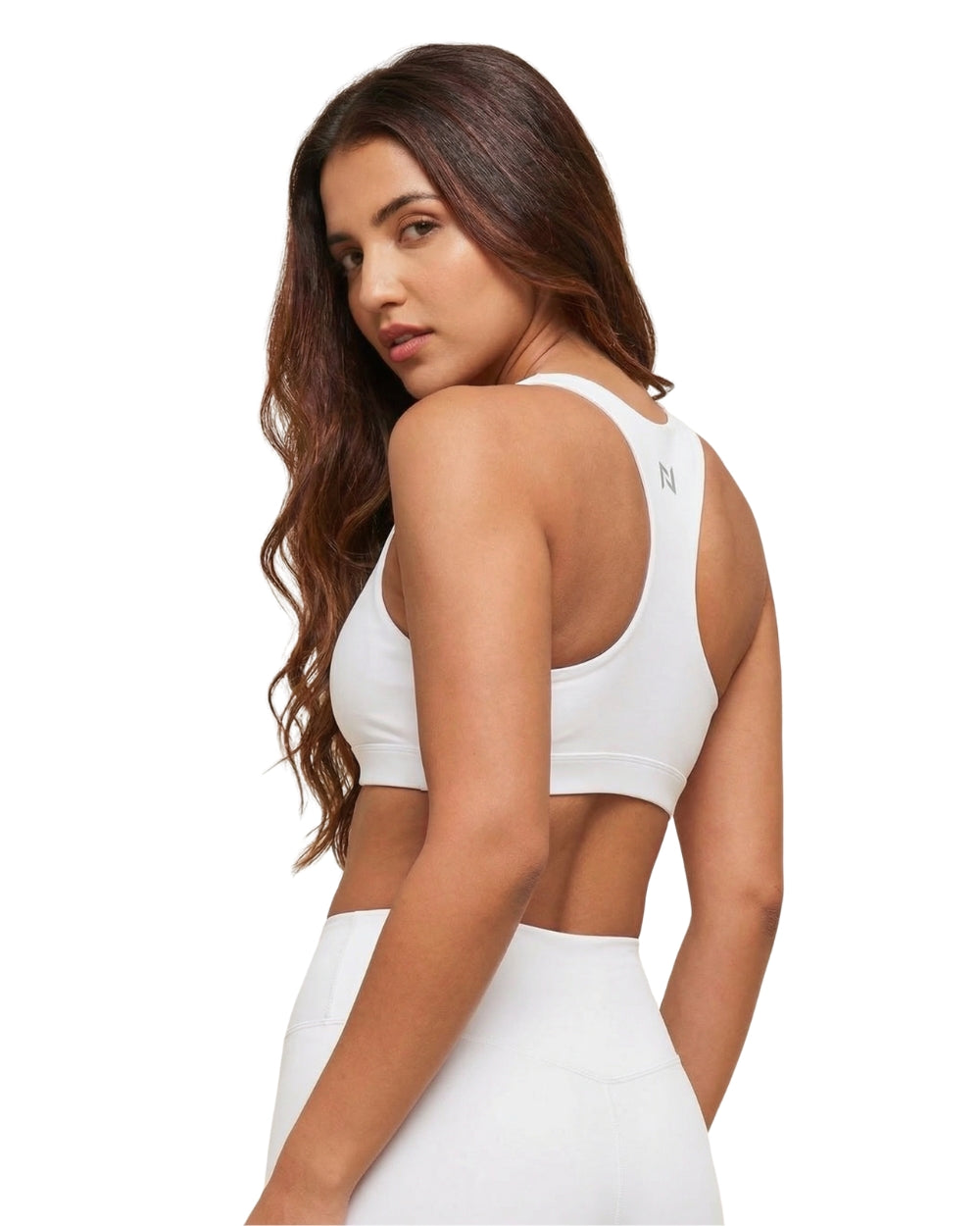 Woman wearing a white sports bra and leggings on a white background