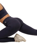 Person wearing navy leggings with a visible brand logo on a white background