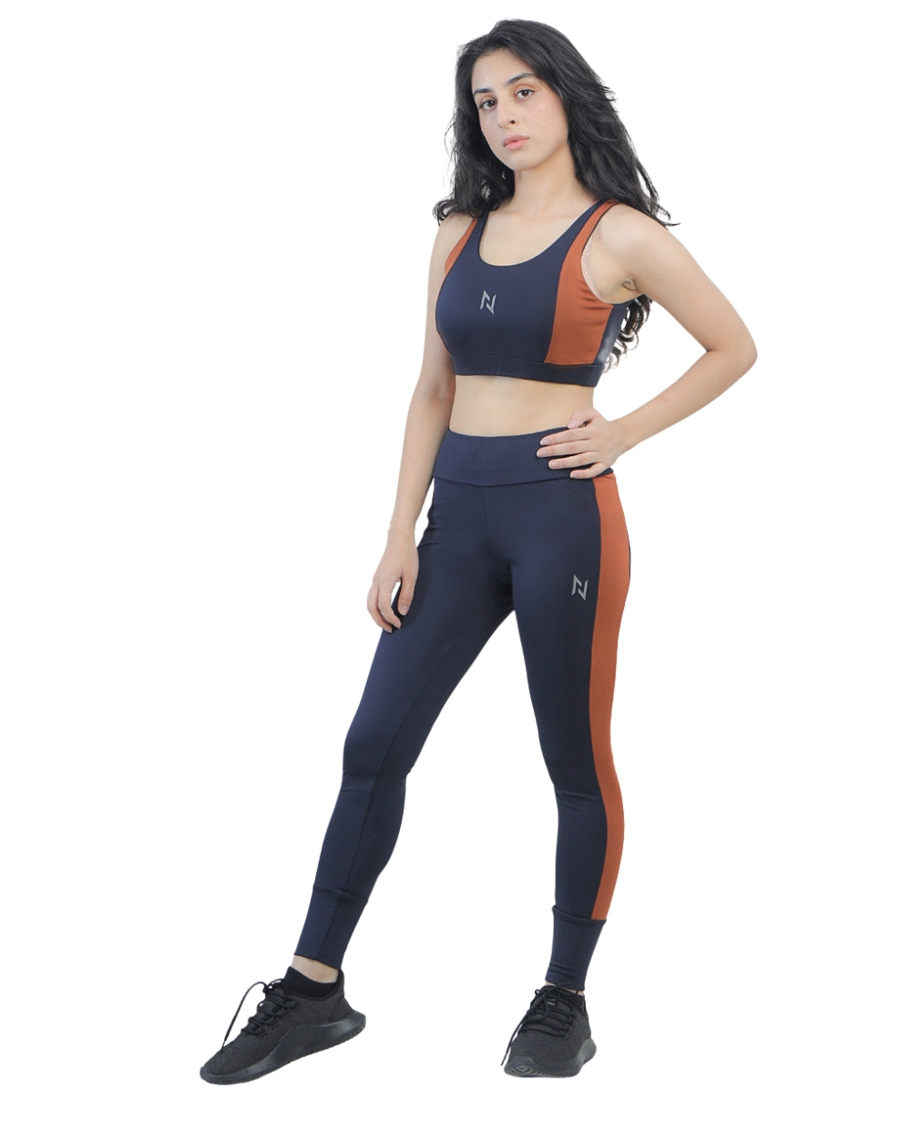 Woman wearing a sports bra and leggings set with a brand logo on a white background