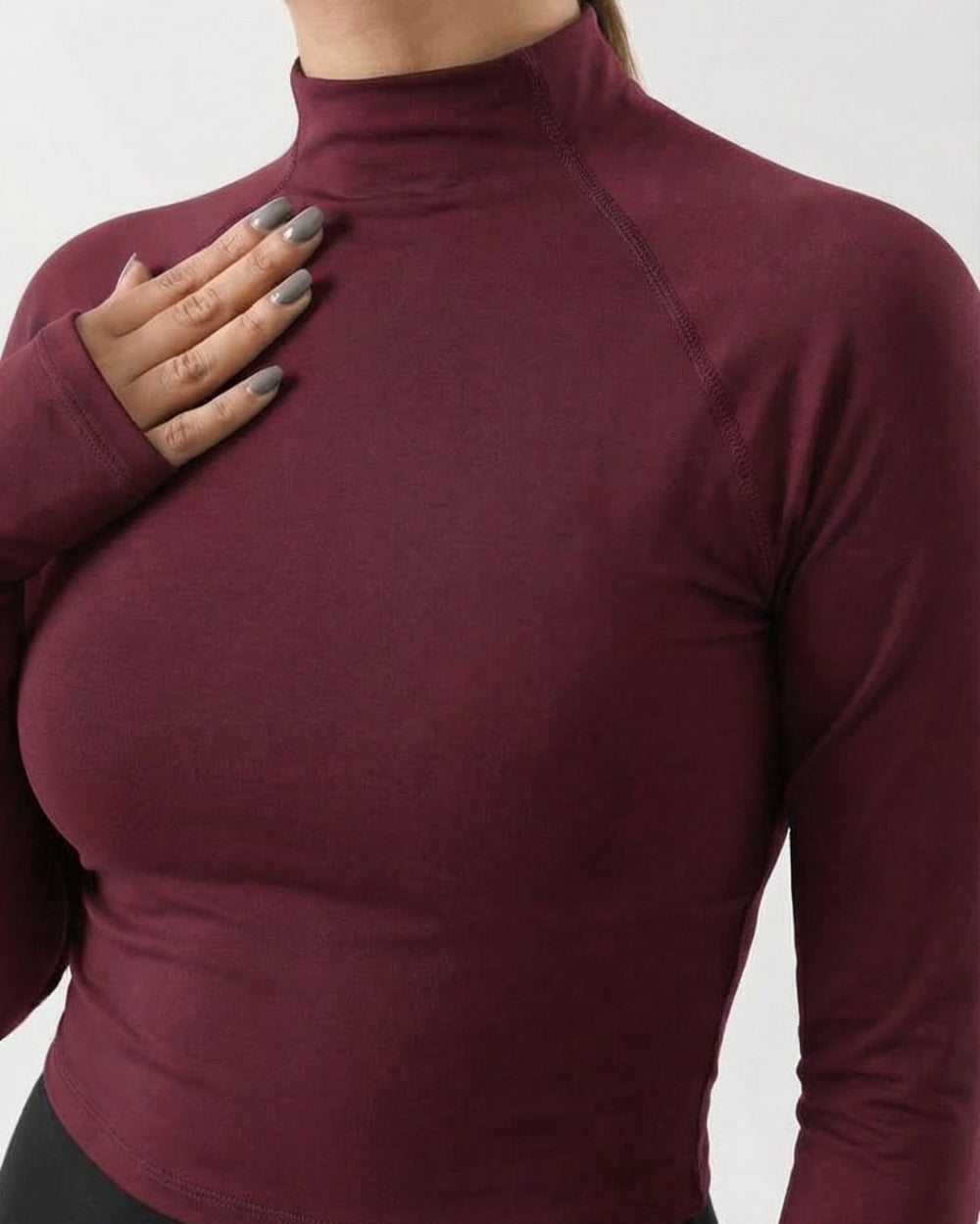 Maroon long-sleeve top worn by a person on a white background