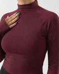 Maroon long-sleeve top worn by a person on a white background