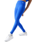 Person wearing blue leggings and white sneakers on a white background