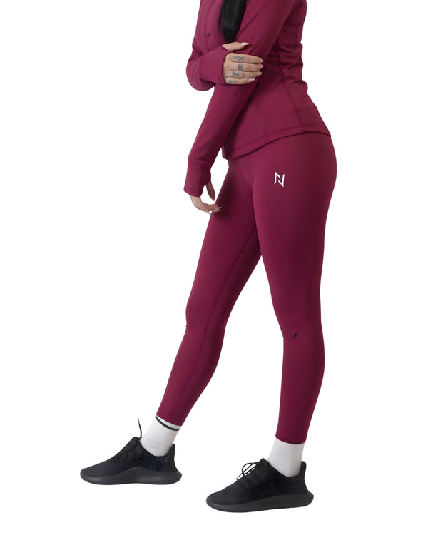 Person wearing a maroon tracksuit with a logo on a white background