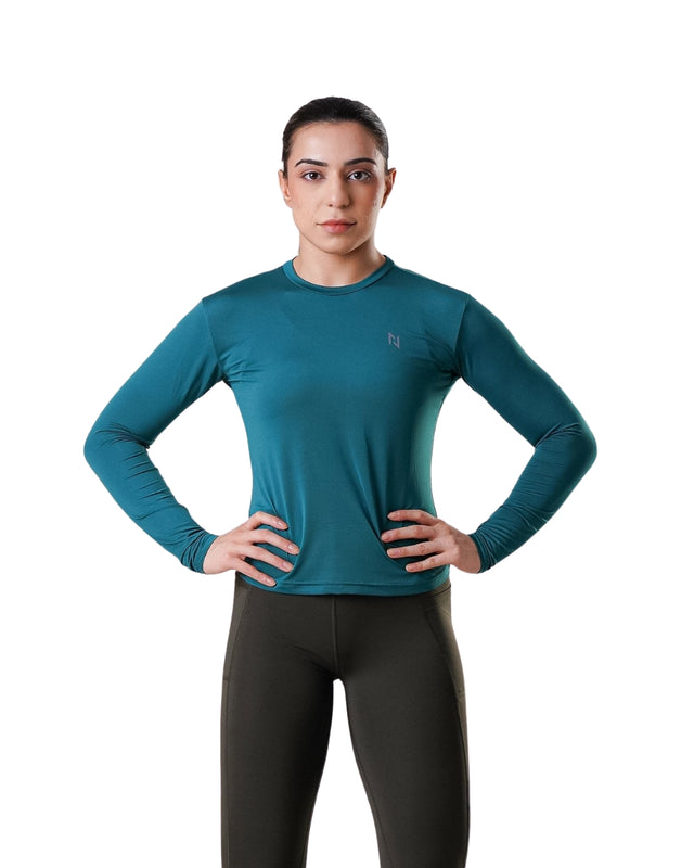 Person wearing a teal long-sleeve athletic shirt and black leggings on a white background