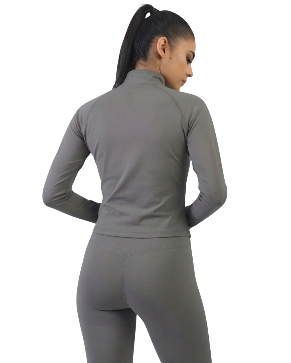 Person wearing a gray long-sleeve top and leggings on a white background