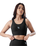 Woman wearing a black sports bra with a logo on a white background