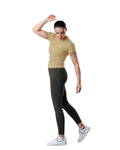 Woman wearing a beige t-shirt and black leggings on a white background