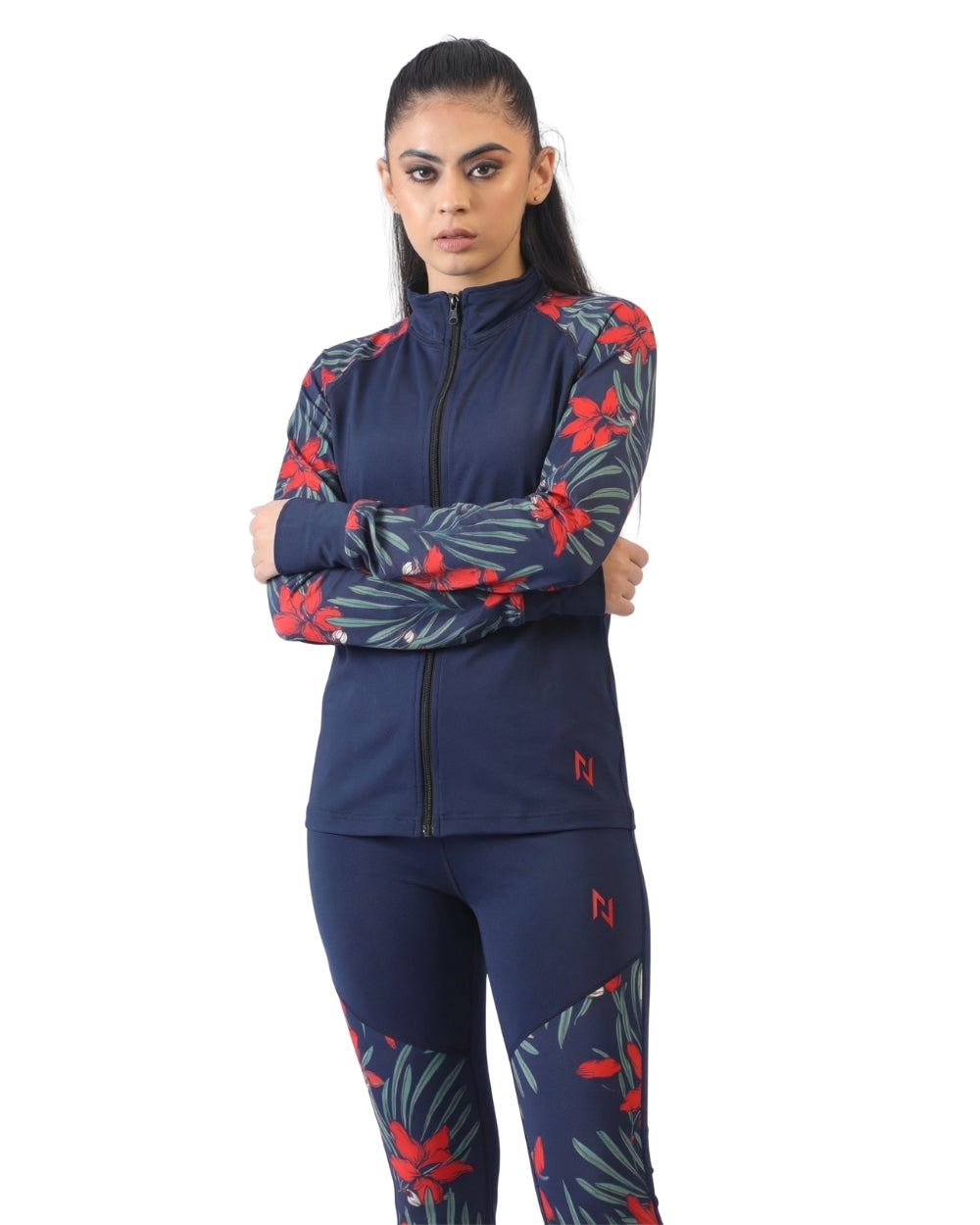 Woman wearing a navy athletic outfit with red and green leaf patterns on a white background