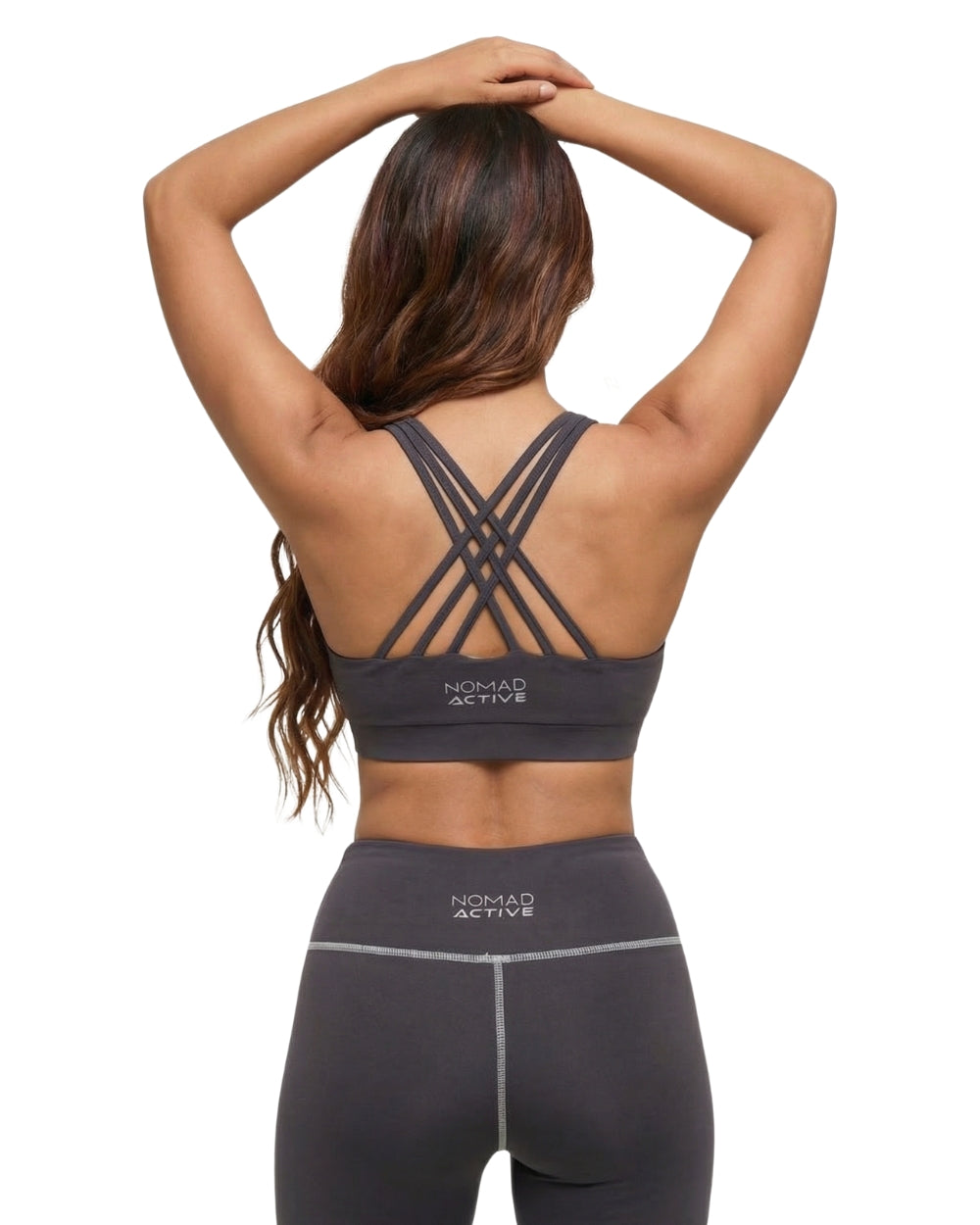 Woman wearing a black sports bra and leggings with 'Nomad Active' branding on a white background