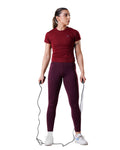Woman in maroon athletic outfit holding a jump rope on a white background