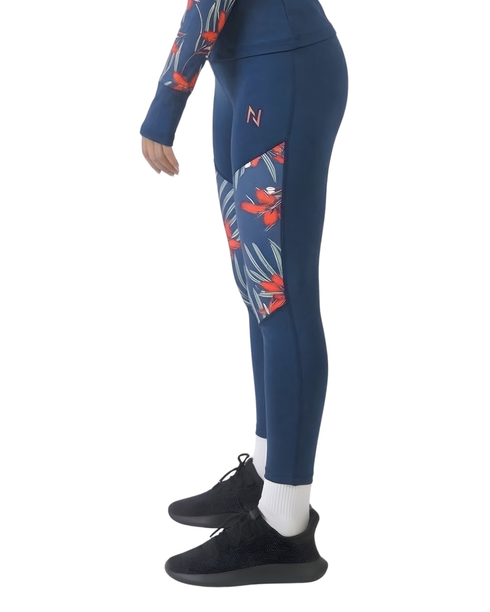 Person wearing blue leggings with red and white patterns on a white background